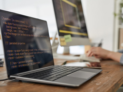 Two screens of code in a quiet room, something being built