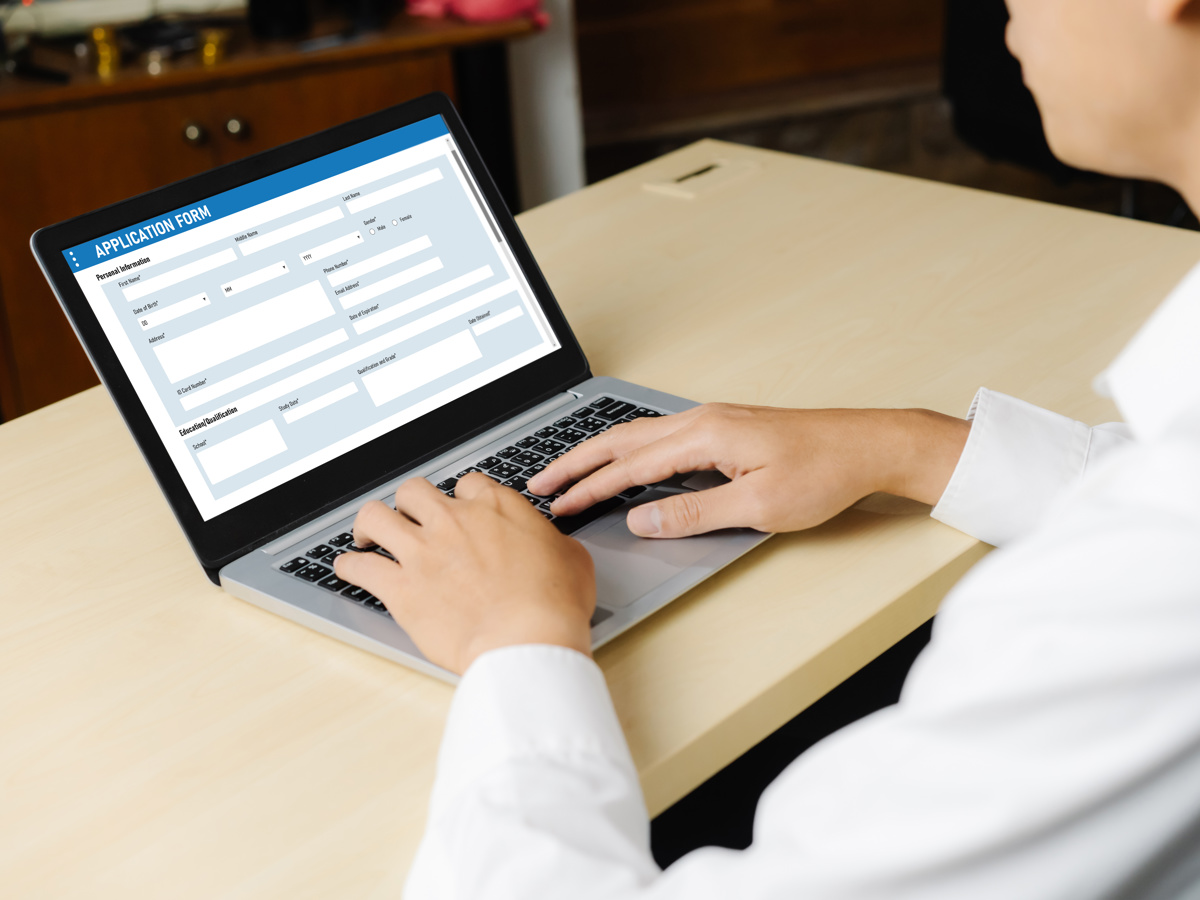 Somebody filling in an application form on a laptop