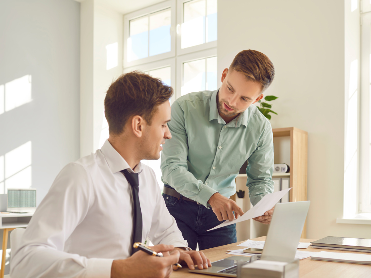 Two colleagues going through figures together at a desk